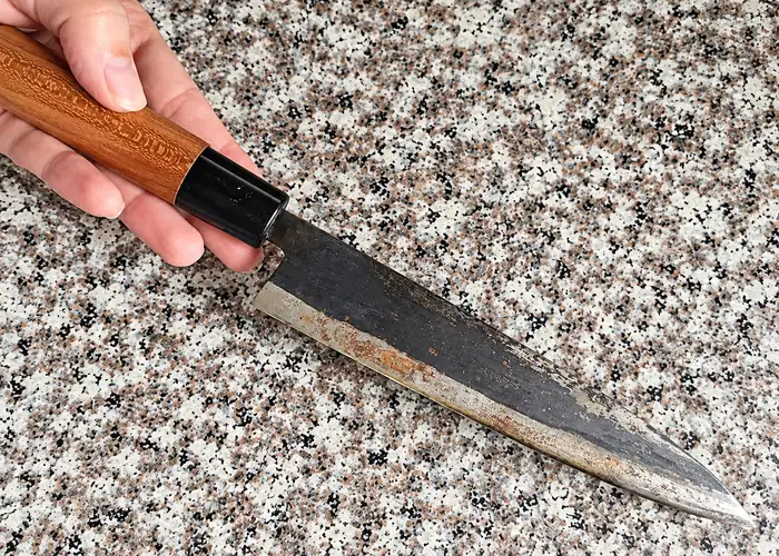 Knife with a worn edge on a hard stone countertop